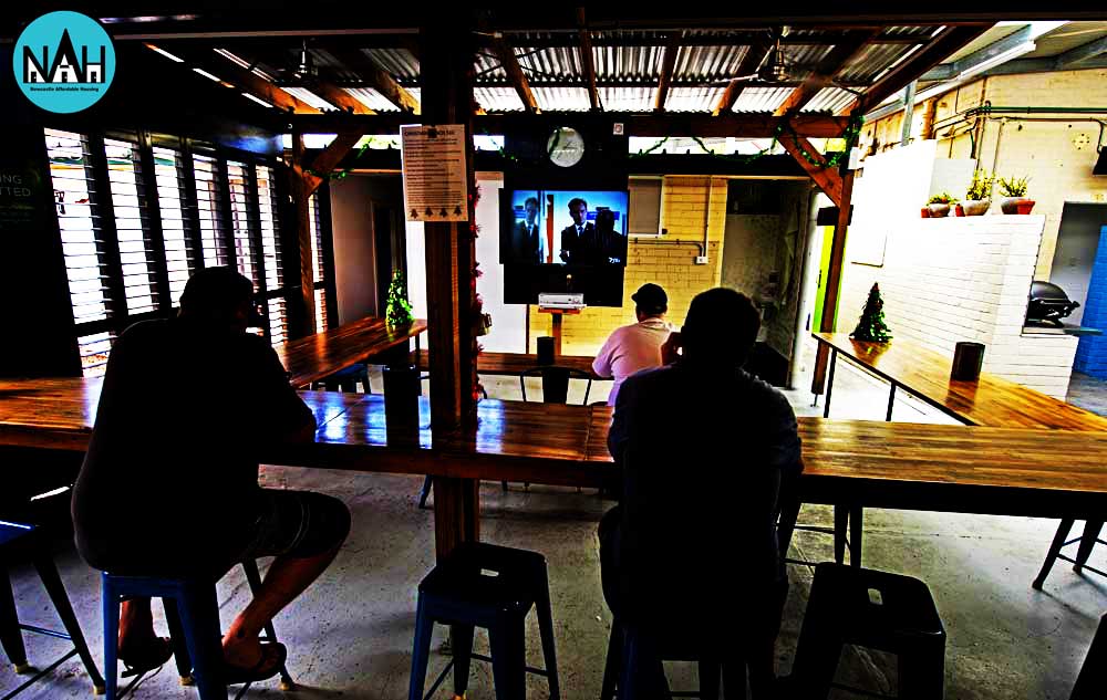 Three men watching tv in the outdoor area at Aaron Buman affordable housing in Carrington NSW